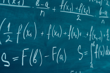 mathematics formulas written on the blackboard. school, education, integral.