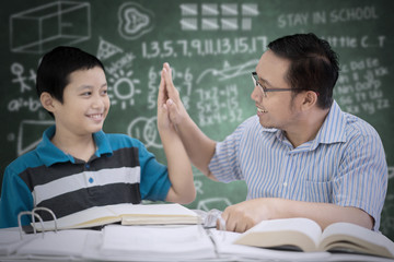 Wall Mural - Male teacher giving high five to his student