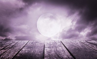Wall Mural - Halloween background. Spooky sky with full moon and wooden table