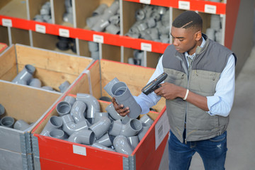 man is scanning pipes by handheld device