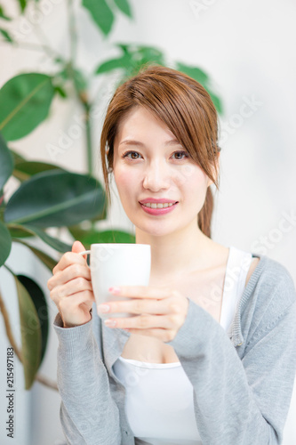 コーヒーカップを手にこちらを見つめる女性 Stock Photo Adobe Stock