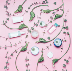 Wall Mural - Natural cosmetic and beauty concept. Flat lay with various cosmetic products with copy space , green flowers and leaves on pastel pink background, top view. Vegan skin care cosmetic