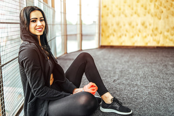 Wall Mural - Cute sporty girl sitting in the gym