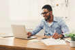 © Prostock-studio - Young black businessman working with laptop