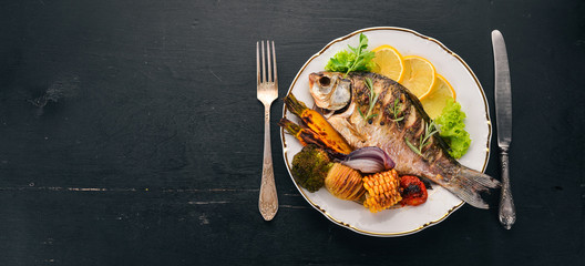 Baked fish carp. On a wooden background. Top view. Copy space.