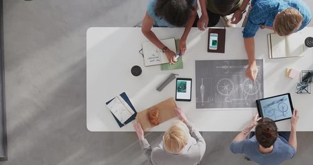 time lapse young multi ethnic design team brainstorming ideas designing bicycle using blueprint 3d render technology in modern startup office workspace top view track