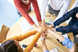 © baranq - Group of students holding hands together and cheering. Startup entrepreneurs during meeting