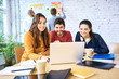 © baranq - Group of young creative workers looking at laptop and brainstorming during meeting. University students studying together