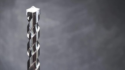 Poster - Silver drill bit rotation on a dark background. Macro view.
