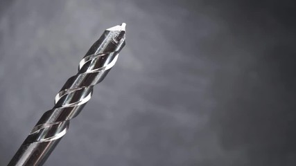 Poster - Silver drill bit rotation on a dark background. Macro view.
