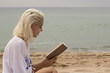 © SircPhoto - pretty blonde girl reading on beach
