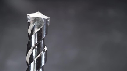 Poster - Silver drill bit rotation on a dark background. Macro view.