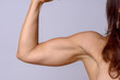 Strong fit mature woman flexing her arm muscles