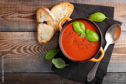 Fotomural Homemade tomato soup with Basil, toast and olive oil on a wooden table