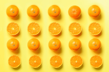 Wall Mural - fruit pattern of fresh orange slices on yellow background. top view. copy space. pop art design, cre