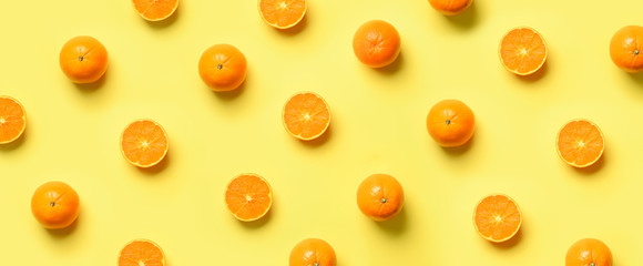 Wall Mural - fruit pattern of fresh orange slices on yellow background. top view. copy space. pop art design, cre