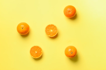 Wall Mural - fruit pattern of fresh orange slices on yellow background. top view. copy space. pop art design, cre