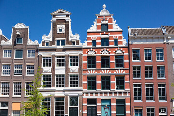 Typical old houses in Amsterdam, Netherlands with blue sky.