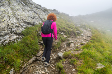 Woman hiking into rocky mountains