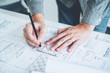 © joyfotoliakid - Architect or engineer working in office on blueprint. Architects workplace