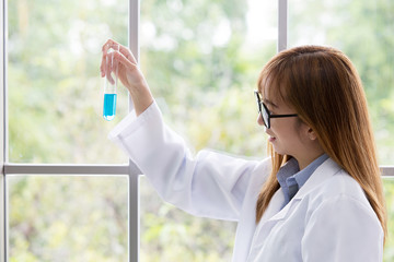 Science whit blue spirit mind. Scientific substance blue in on her hand at lab a background. Beautiful smiling female doctor or Scientist holding Scientific substance organic. asian people.