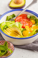 Canvas Print - Green zucchini noodles salad with tomatoes, avocado and basil. Healthy vegan zucchini pasta.