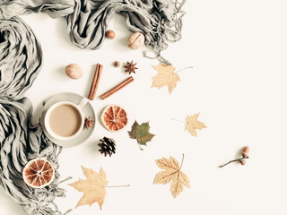 Autumn composition. Cup of coffee, dried leaves, cinnamon, star anise, cones, light background. Autumn elegant concept. Flat lay, top view, copy space 