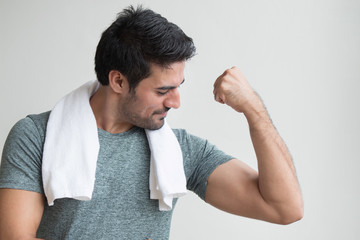 strong fitness man working out in gym; portrait of happy, strong, healthy asian indian man body training, working out his muscle in fitness gym; south asian, north indian adult man model