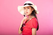 © Sasils Production - Portrait of attractive woman in summer outfit and hat posing secret hush while standing and looking at camera isolated over pink background.