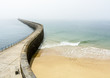 The Mole des Noires, the long breakwater of the walled city of Saint-Malo in Brittany, France, and the Mole beach by a sunny and misty weather.