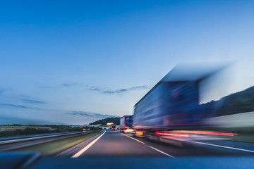 background photograph of a highway. truck on a motorway, motion blur, light trails. evening or night