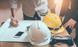 © wirat - Teams of engineers architect meeting design project discussion work concept at construction site in the office.