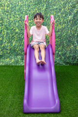 Wall Mural - Asian Chinese Little Girl Playing on the slide