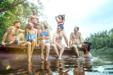 Wall Mural - Enjoying river party with friends. Group of beautiful happy young people at the river together