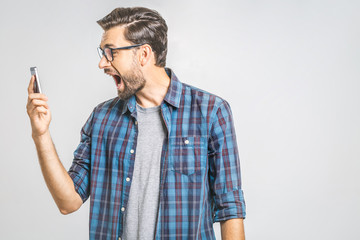 Young caucasian man angry, frustrated and furious with his phone, angry with customer service