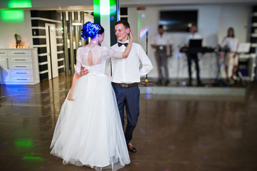 Romantic newly married couple performing their first dance in the restaurant.