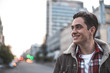 © Yakobchuk Olena - Side view of cheerful attractive man walking on street on his own.  He is looking sideways and smiling. Copy space in left side