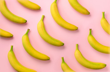 Wall Mural - colorful fruit pattern. bananas over pink background. top view. pop art design, creative summer conc