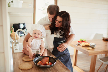 The mother,father and son cooking a meat