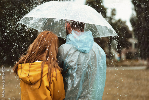 Fotografía Male and female strolling under one umbrella together