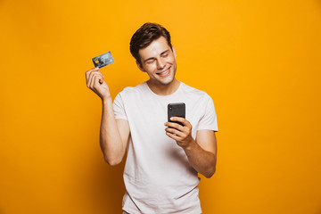 Canvas Print - Portrait of a satisfied young man holding mobile phone