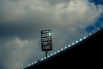 Wall Mural - Light tower reflectors at a stadium during nightime.