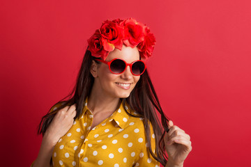 Wall Mural - A young woman in studio with sunglasses and red flower headband.