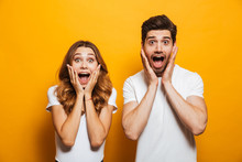 Image Of Young People Man And Woman In Basic Clothing Screaming In Surprise Or Delight And Touching Cheeks, Isolated Over Yellow Background