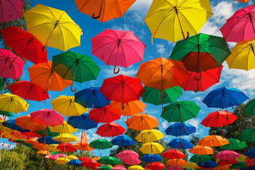 Lots of colorful umbrellas in the sky. City decoration