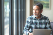© ChayTee - Mature man with white stylish short beard looking outside window. Casual lifestyle of retired hispanic people or adult asian man thinking and feeling confident sitting at modern coffee shop cafe.