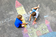 © Irina Schmidt - Two little kids boys drawing knight castle with colorful chalks on asphalt. Happy siblings and friends having fun with creating chalk picture and painting. Creative leisure for children in summer.