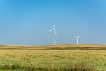 Modern wind farm with big wind turbines towers, source for renewable green energy