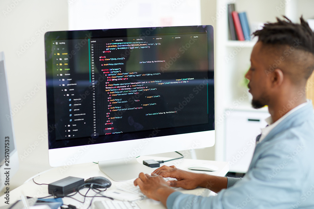Busy African web developer coding computer language while sitting at ...