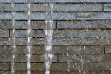 Stone Wall Water Feature, With Blurred Water And Rock Bricks, As A Background